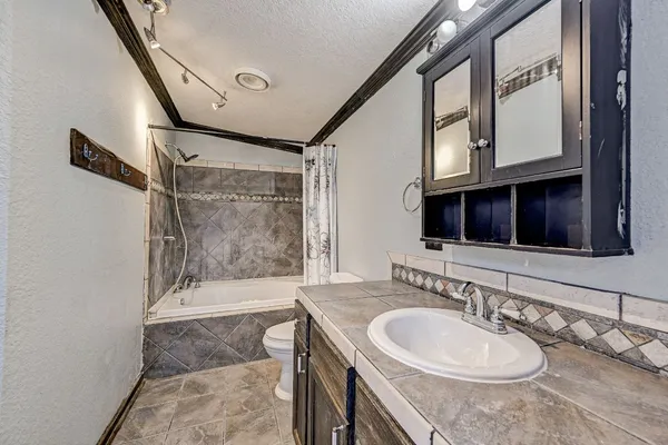 a bathroom with a granite countertop sink mirror vanity and bathtub