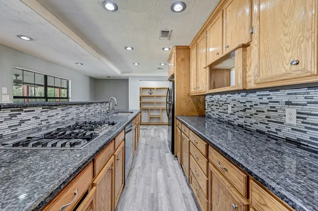 a kitchen with stainless steel appliances granite countertop a stove and a sink