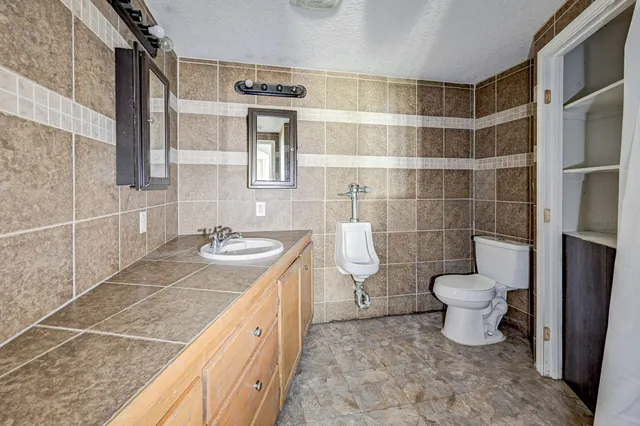 a bathroom with a granite countertop sink toilet and shower
