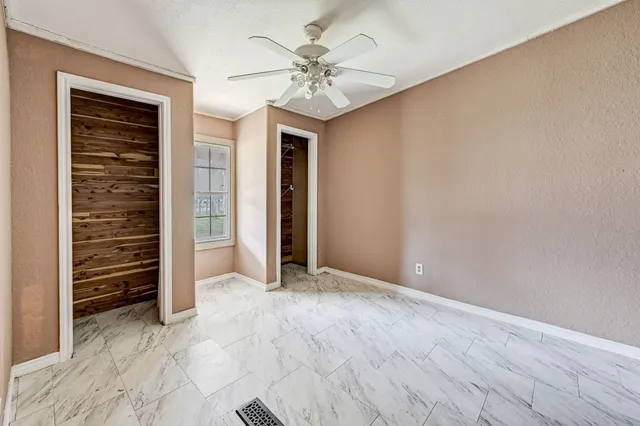 an empty room with closet and ceiling fan