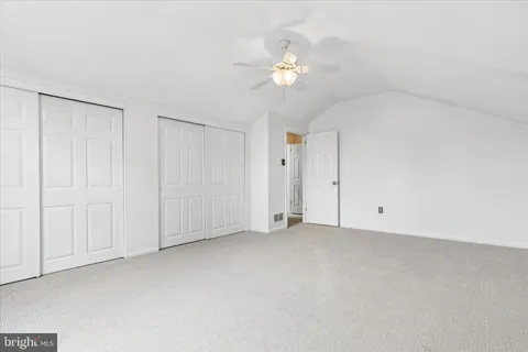 a view of an empty room with a chandelier fan