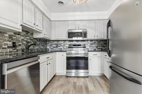 a kitchen with stainless steel appliances a stove a sink and a microwave