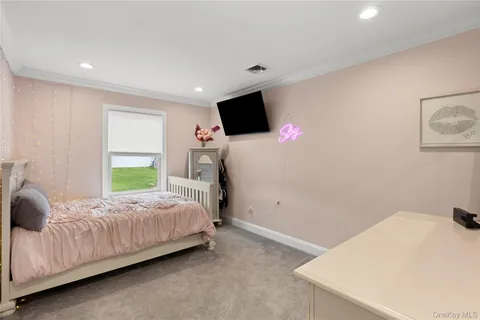 a bedroom with a bed window and a flat screen tv
