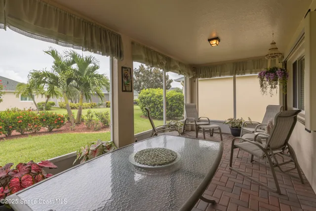 a living room with patio furniture and a large window