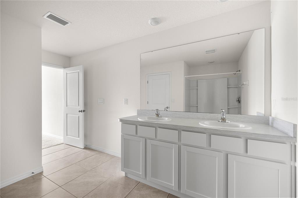 6563 Southeast 1st Loop Ocala, FL 34472 - Photo 13 of 24 a bathroom with a double vanity sink and mirror