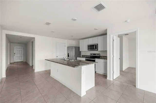a kitchen with stainless steel appliances granite countertop a sink and a stove