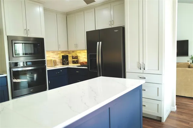a kitchen with granite countertop a refrigerator and a stove