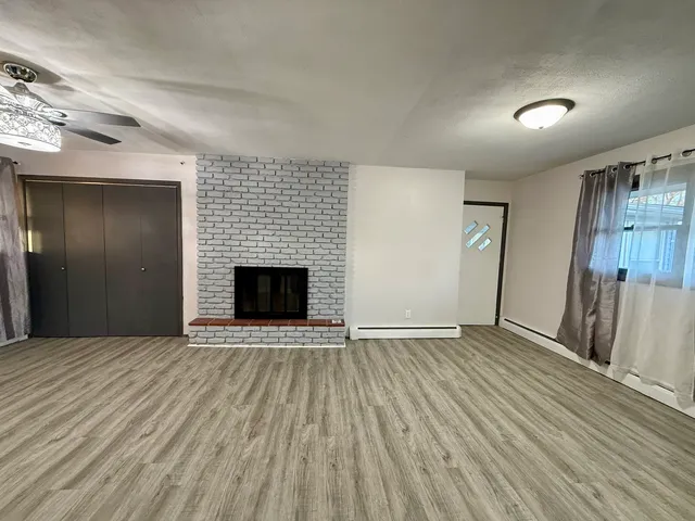 an empty room with wooden floor and fireplace