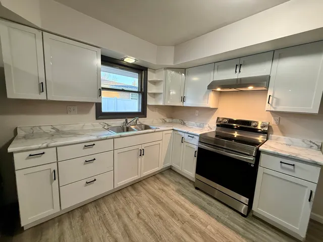a kitchen with granite countertop white cabinets and white appliances