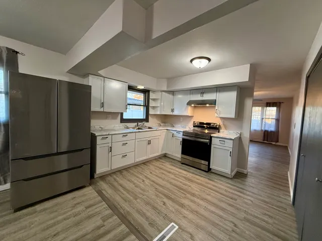 a kitchen with granite countertop white cabinets and stainless steel appliances