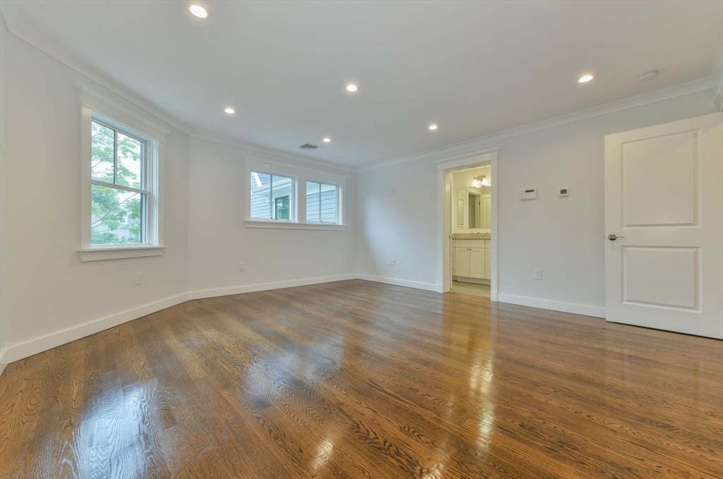 28 Sumner Street, Unit 28 Newton, MA 02459 - Photo 13 of 32 an empty room with wooden floor and windows