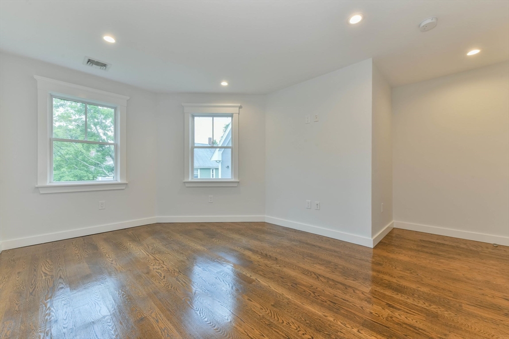 28 Sumner Street, Unit 28 Newton, MA 02459 - Photo 15 of 32 an empty room with wooden floor and windows