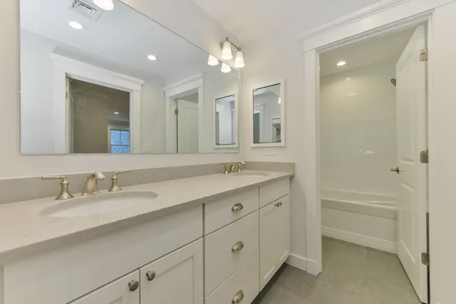 a bathroom with a granite countertop sink mirror vanity and toilet