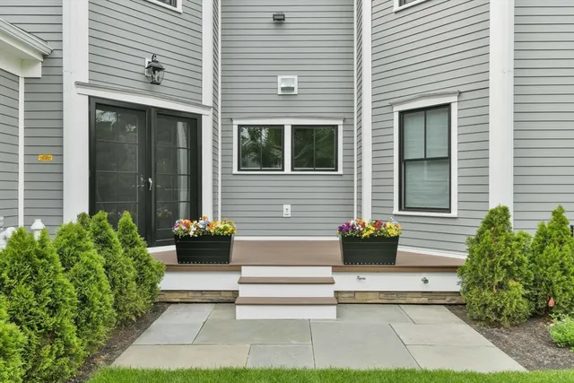 a white house with table and chairs and potted plants in front of door