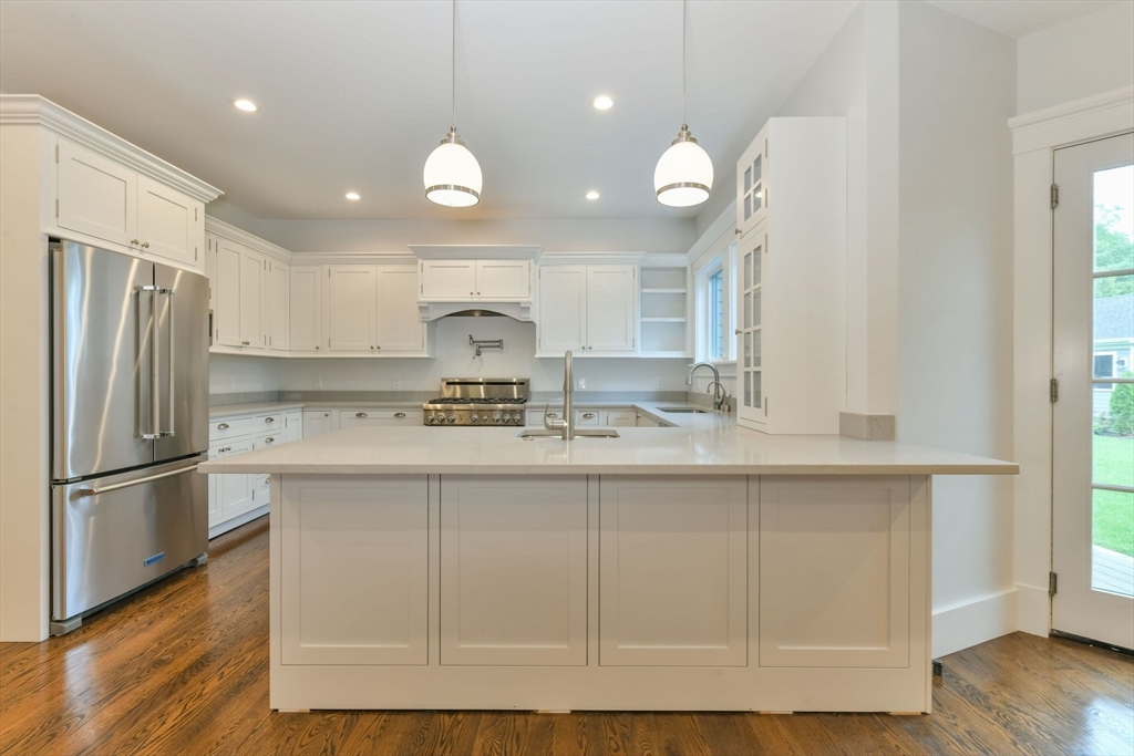 28 Sumner Street, Unit 28 Newton, MA 02459 - Photo 6 of 32 a kitchen with kitchen island white cabinets and stainless steel appliances
