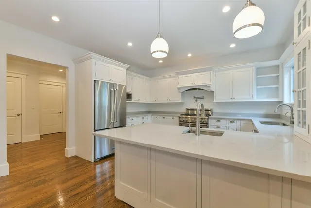 a kitchen with stainless steel appliances granite countertop a sink refrigerator and cabinets