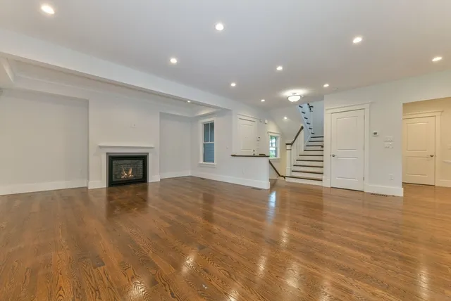 a view of empty room with wooden floor and fireplace