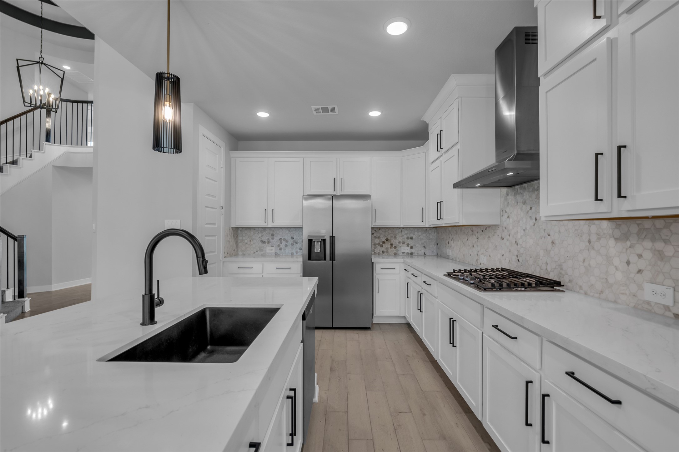 215 Flower Moon Court Conroe, TX 77318 - Photo 14 of 44 a kitchen with stainless steel appliances kitchen island a sink a stove and cabinets