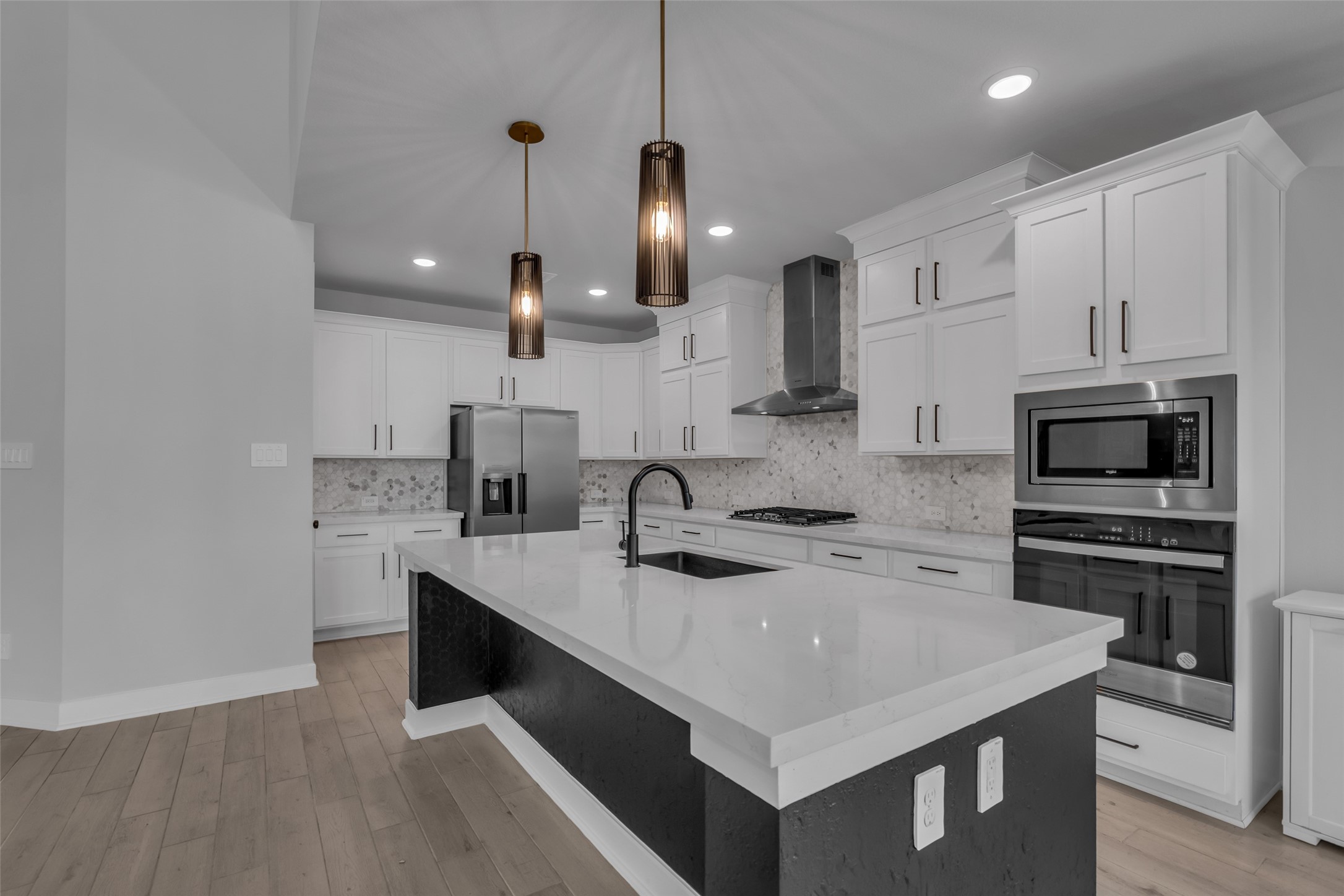 215 Flower Moon Court Conroe, TX 77318 - Photo 15 of 44 a kitchen with a sink a stove a microwave and cabinets