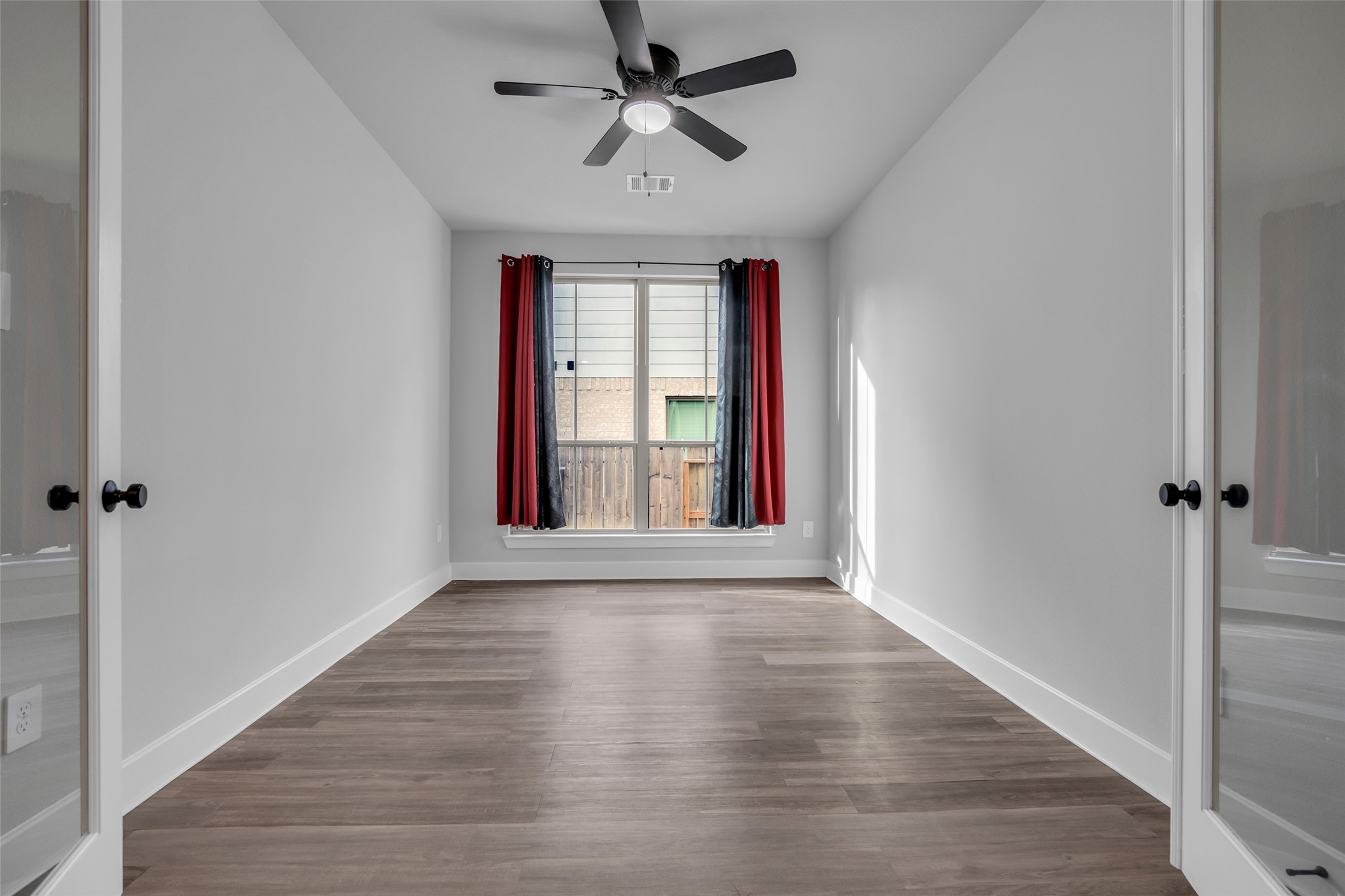 215 Flower Moon Court Conroe, TX 77318 - Photo 16 of 44 a view of an empty room with a window and wooden floor