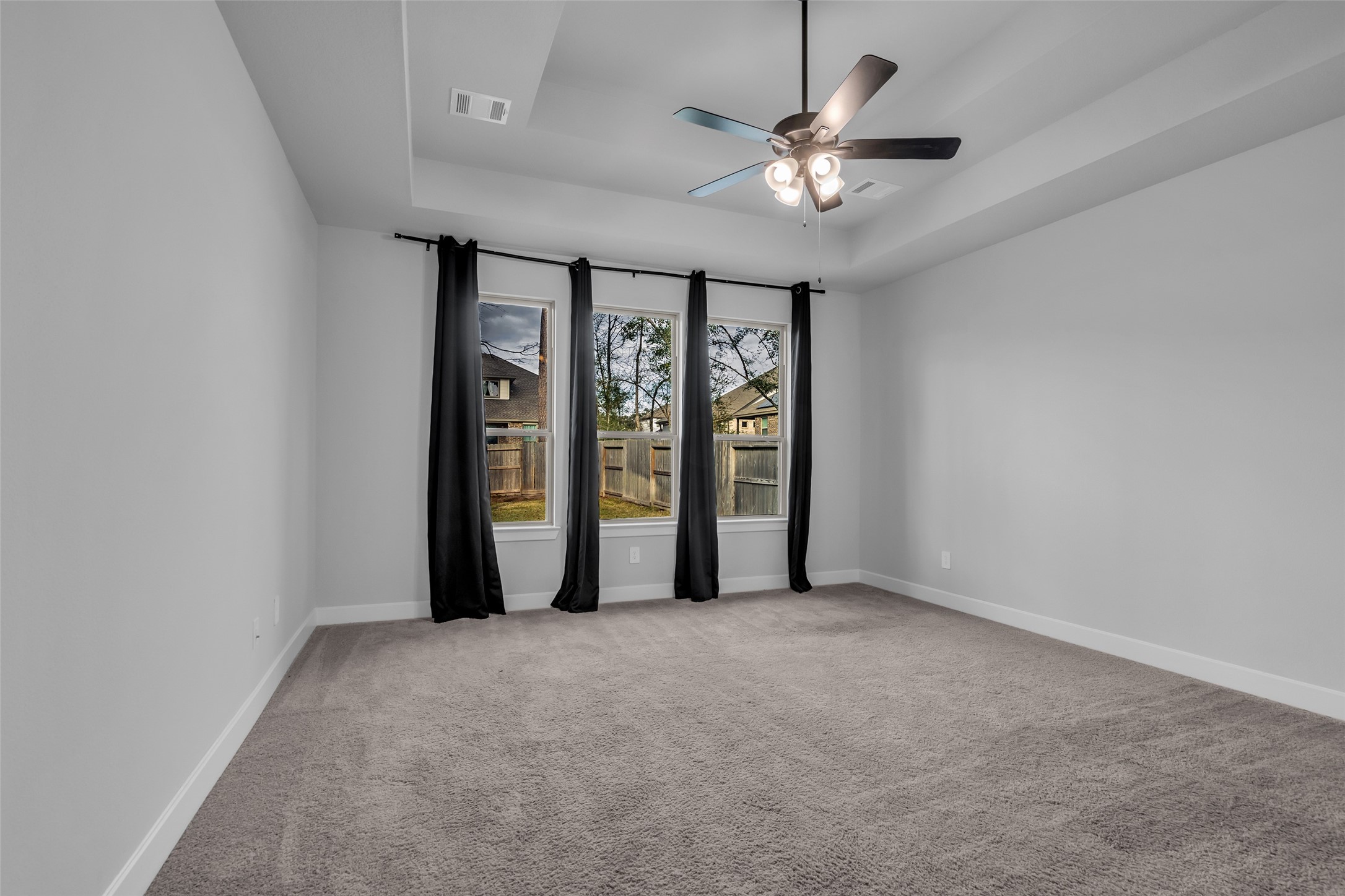 215 Flower Moon Court Conroe, TX 77318 - Photo 20 of 44 an empty room with chandelier fan and windows