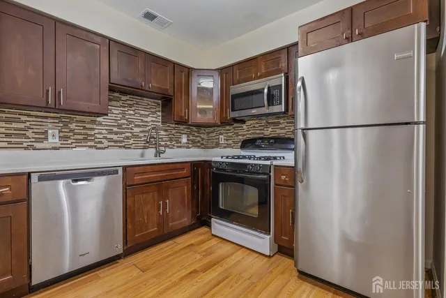 a kitchen with granite countertop a refrigerator stove and microwave