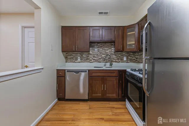 a kitchen with stainless steel appliances granite countertop a refrigerator and a stove