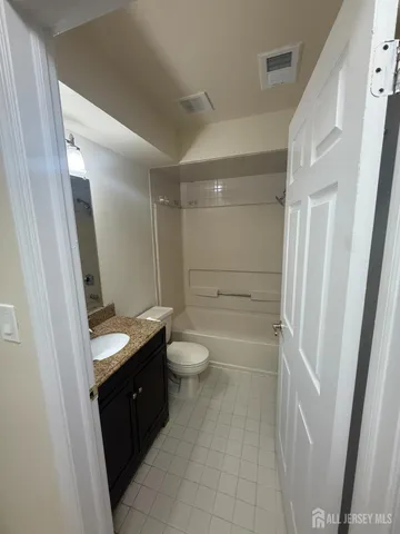 a bathroom with a granite countertop sink toilet a mirror and shower