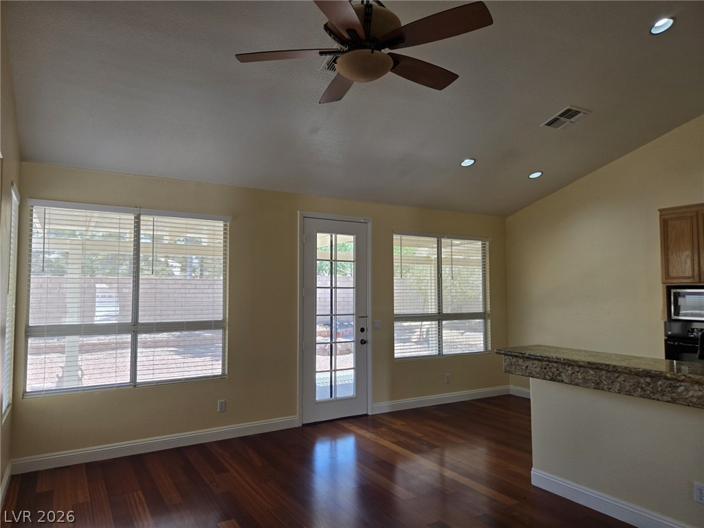 8417 San Ramon Drive Las Vegas, NV 89147 - Photo 11 of 33 Rich hardwood flooring complements a practical breakfast bar in this airy living space.