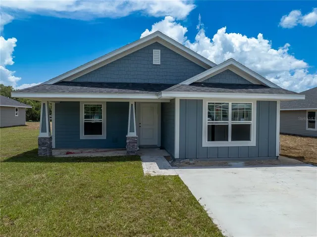 a front view of a house with a yard outdoor seating and garage
