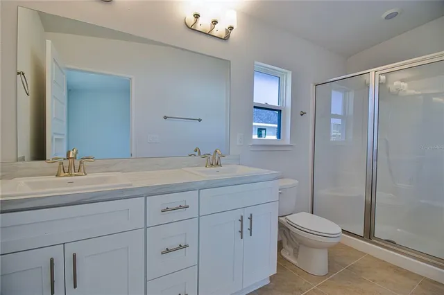 a bathroom with a double vanity sink toilet and shower