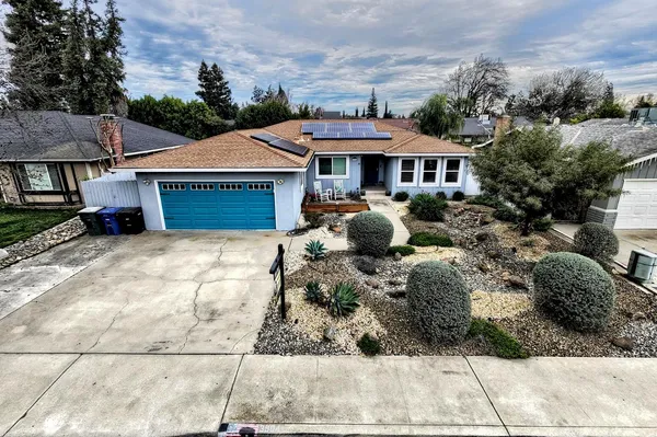 a view of a house with backyard sitting area and barbeque oven