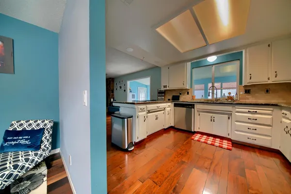 a room with furniture a wooden floor and next to a window