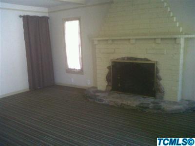 1143 B Street Reedley, CA 93654 - Photo 3 of 4 a view of empty room with window and fireplace