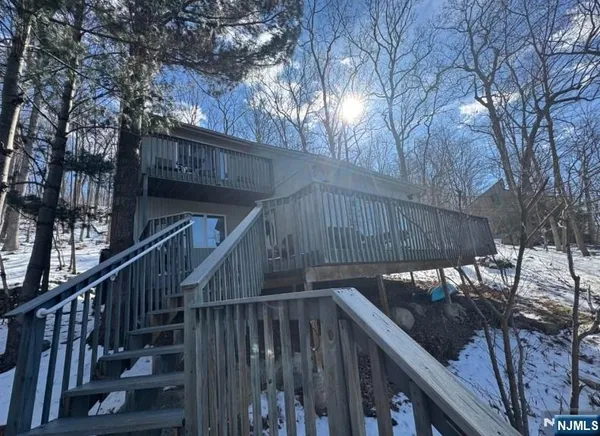 a view of deck with wooden fence and trees