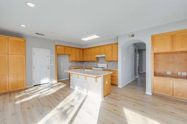 a large kitchen with a sink and a large window
