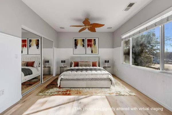 a living room with a bed and glass walk in closet