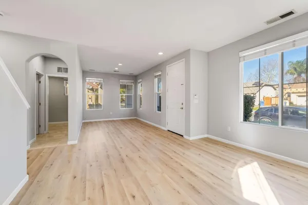 a view of empty room with window and wooden floor