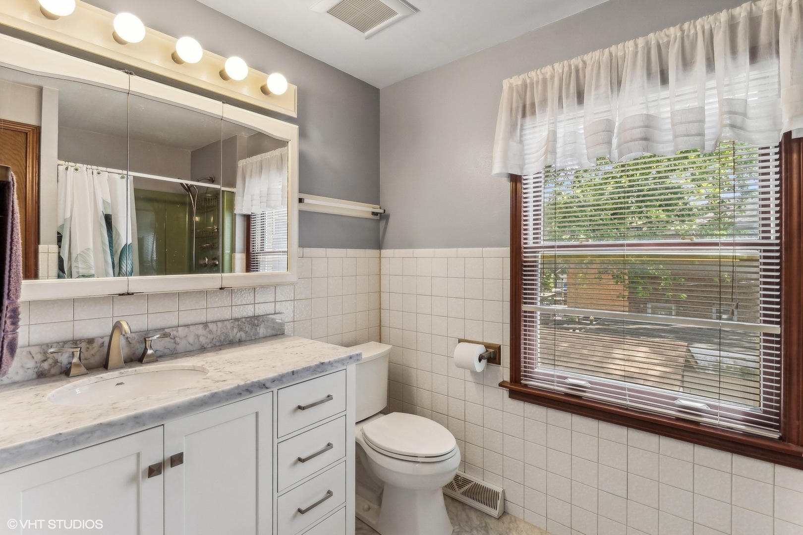 405 North Pine Street Mount Prospect, IL 60056 - Photo 14 of 22 a bathroom with a granite countertop toilet a sink a mirror a vanity and a shower