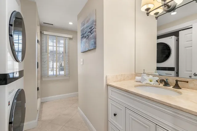 a en suite bathroom with a granite countertop sink and a mirror
