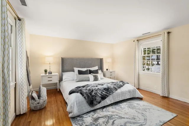 a bedroom with a bed and wooden floor