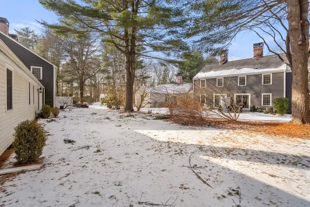 a front view of a house with a yard covered in snow