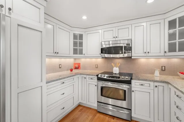 a kitchen with white cabinets and appliances