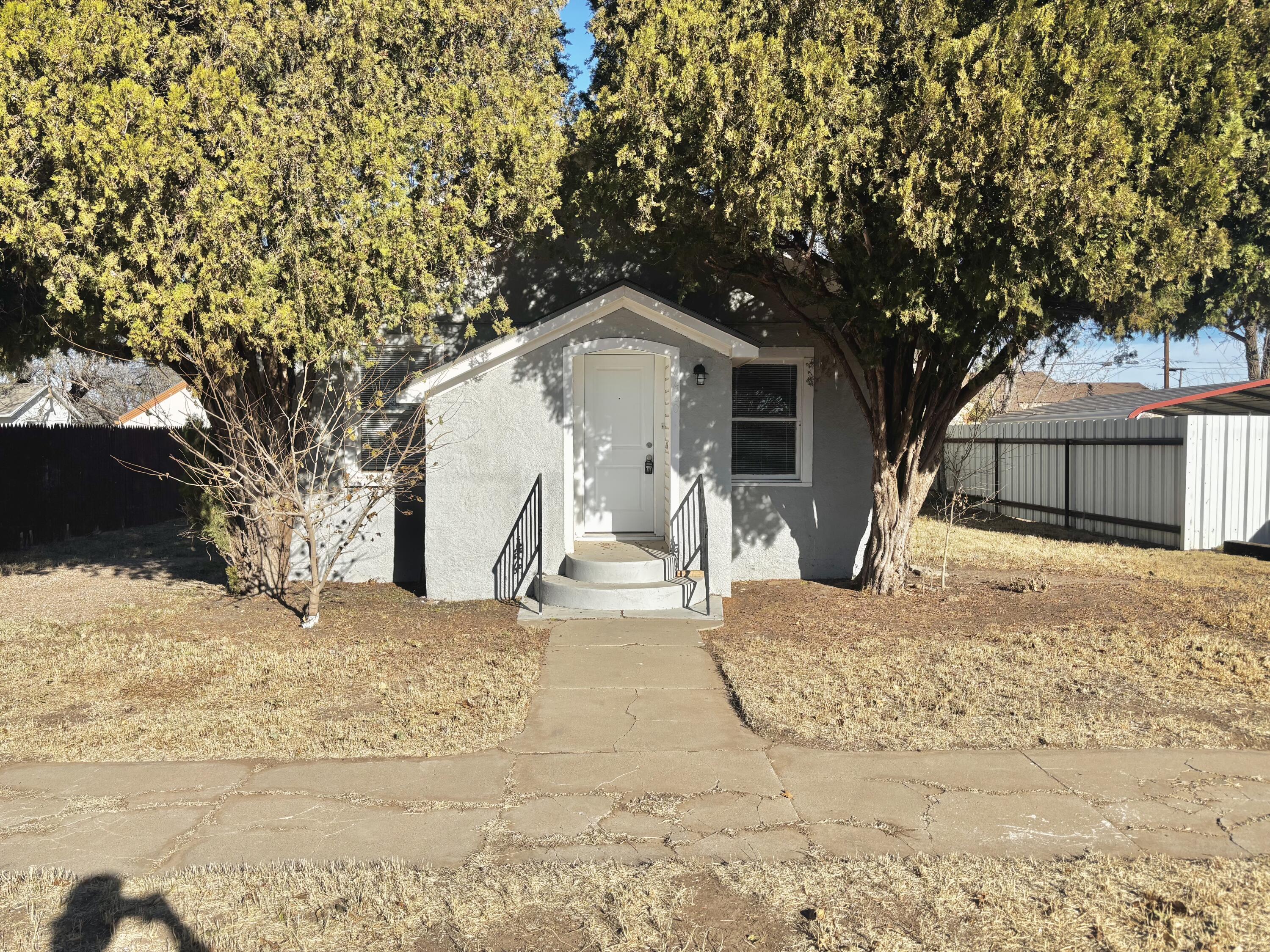 a front view of a house with a yard covered in snow