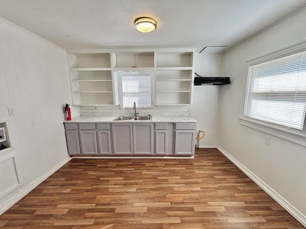 a view of a kitchen with cabinets and wooden floor