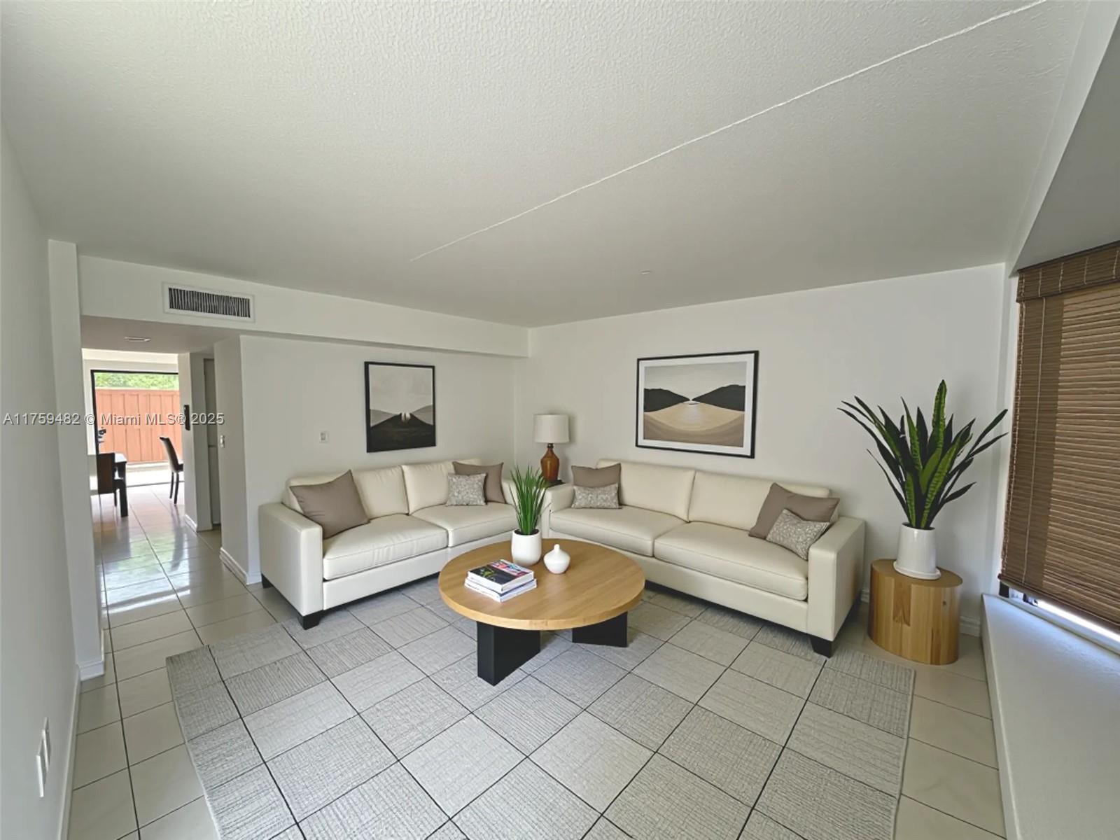 10023 Southwest 77th Court Miami, FL 33156 - Photo 1 of 22 a living room with furniture and a potted plant