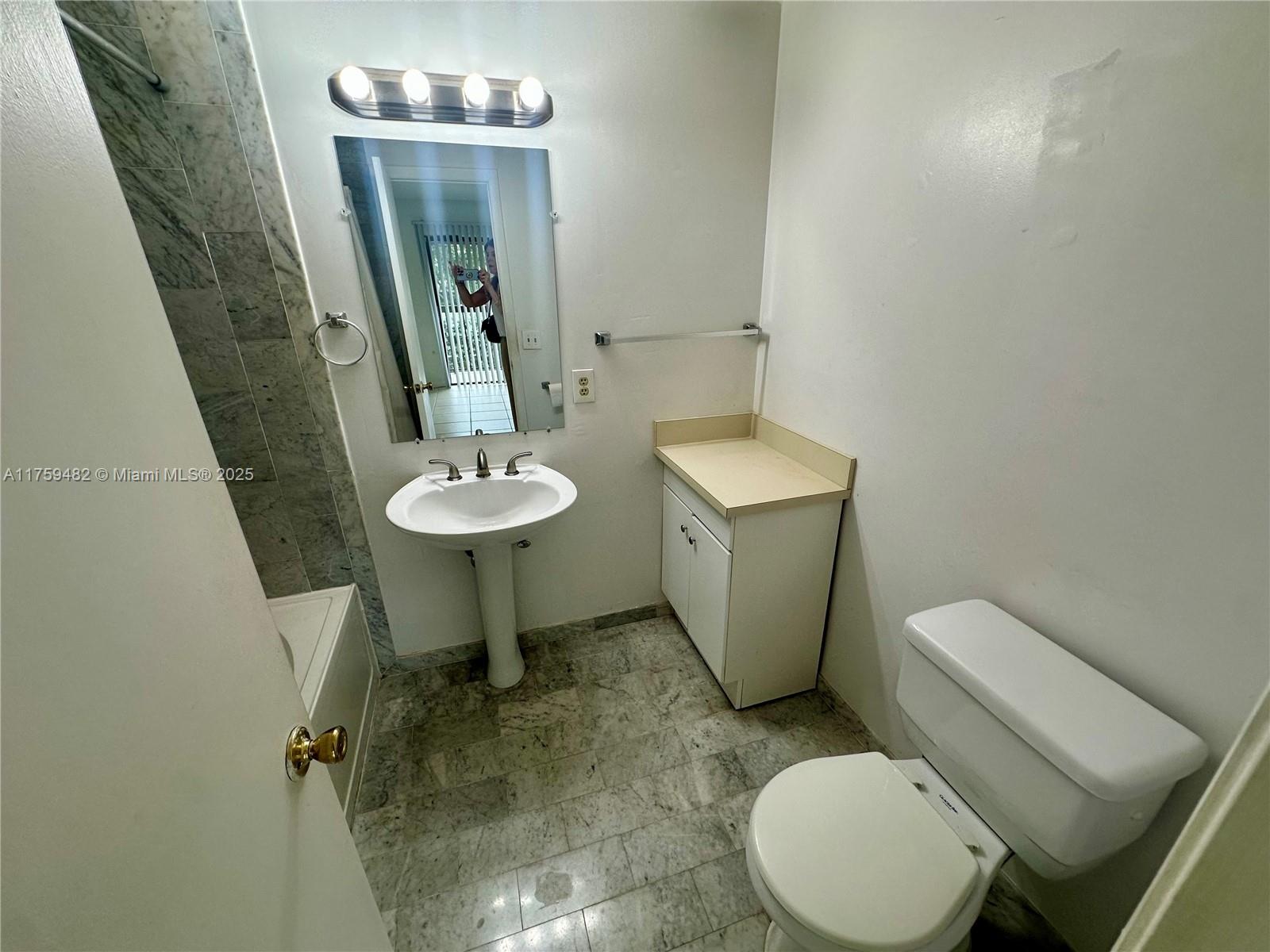 10023 Southwest 77th Court Miami, FL 33156 - Photo 11 of 22 a bathroom with a toilet sink and mirror