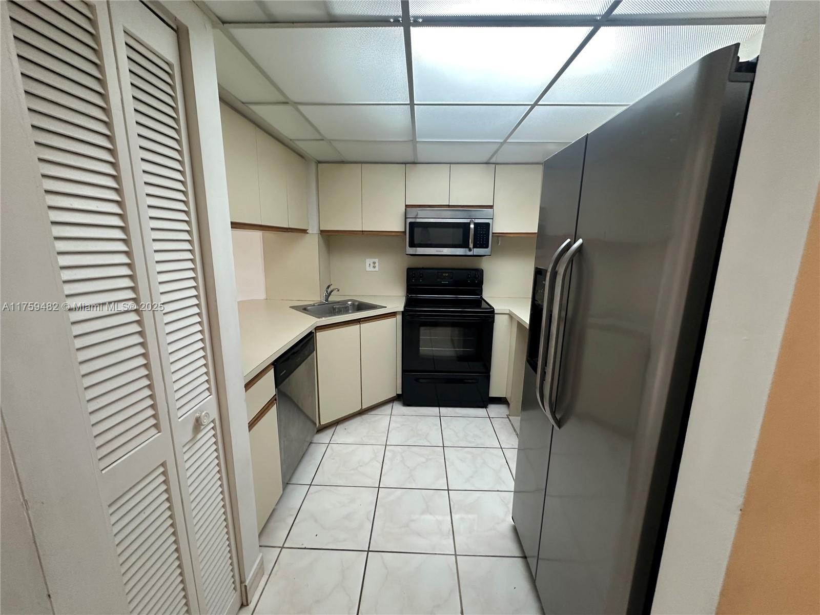 10023 Southwest 77th Court Miami, FL 33156 - Photo 7 of 22 a kitchen with stainless steel appliances a refrigerator and a sink