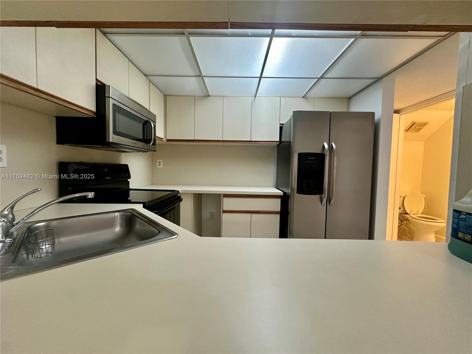 10023 Southwest 77th Court Miami, FL 33156 - Photo 8 of 22 a kitchen with stainless steel appliances a sink a refrigerator and a sink