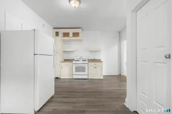 a kitchen with white cabinets and white appliances
